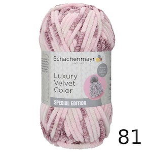 Può includere: Un gomitolo di filato Schachenmayr Luxury Velvet Color nei toni del rosa e del bianco. L'etichetta recita "Luxury Velvet Color SPECIAL EDITION" e include un disegno di un cappello lavorato a maglia. Il numero "81" è visibile.