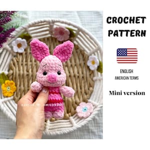 Könnte beinhalten: Ein gehäkeltes rosa Ferkel-Amigurumi mit einem rot-rosa gestreiften Hemd. Das Ferkel hat große Ohren und eine kleine rosa Nase. Das Bild enthält auch den Text "CROCHET PATTERN" und "ENGLISH AMERICAN TERMS Mini version".