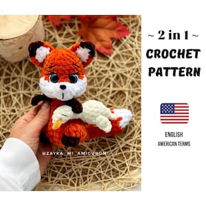 Könnte beinhalten: Gehäkelte Fuchspuppe in Orange, Weiß und Braun, die einen weißen und gelben Vogel hält. Die Puppe hat blaue Augen. Der Text auf dem Bild lautet: "~ 2 in 1 ~ CROCHET PATTERN" und "ENGLISH AMERICAN TERMS".