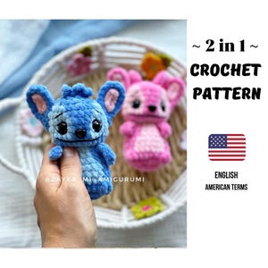 Op de afbeelding: Een haakpatroon met twee stripfiguren, een blauwe en een roze. Het blauwe personage wordt in een hand gehouden. De afbeelding bevat de tekst "~ 2 in 1 ~ CROCHET PATTERN" en "ENGLISH AMERICAN TERMS" met een Amerikaanse vlag.