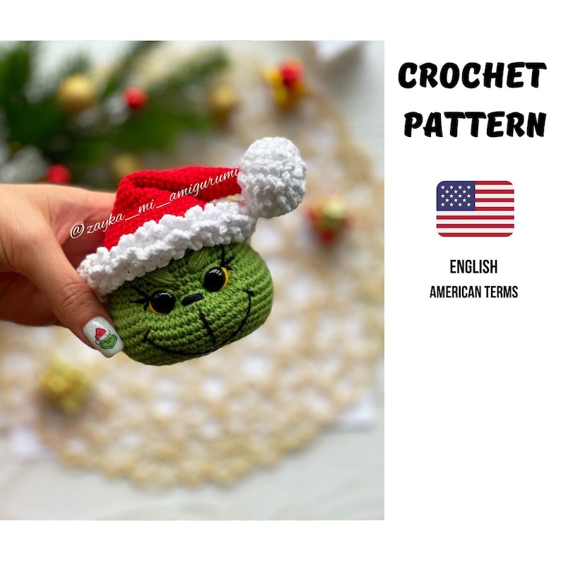 May include: A green crocheted Grinch figure wearing a red and white Santa hat. The amigurumi has a smiling face with black eyes and a stitched mouth. The image includes text that says "CROCHET PATTERN" and "ENGLISH AMERICAN TERMS".