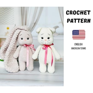 Könnte beinhalten: Zwei gehäkelte Stofftiere: ein Hase und eine Katze. Der Hase ist hellrosa mit langen, schlaffen Ohren und einem rosa Band. Die Katze ist weiß mit einem rosa Band. Das Bild enthält den Text "CROCHET PATTERN" und "ENGLISH AMERICAN TERMS".