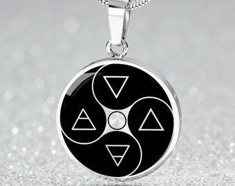 May include: A silver pendant necklace featuring a circular pendant with a black and white design. The pendant has a yin-yang style with four white triangles and a central circle. The necklace chain is a silver snake chain.