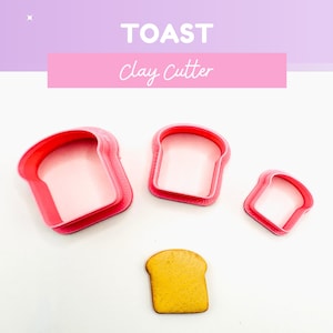May include: A set of three red plastic toast-shaped clay cutters of varying sizes, with a single baked toast piece. The image includes the text "TOAST Clay Cutter" in pink and white.