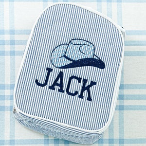 May include: A blue and white striped fabric lunch bag with a white embroidered cowboy hat and the name "JACK" in blue.