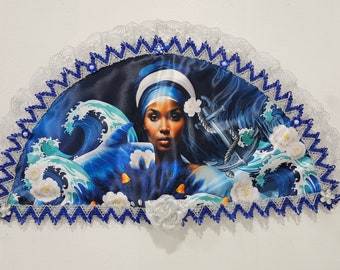Peut inclure: Un éventail bleu et blanc avec un visage de femme et des vagues. L'éventail est décoré de fleurs blanches et de perles bleues.