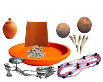 May include: A collection of items used in a traditional Hindu ceremony. The items include a clay pot, a plate with cowrie shells, two coconuts, a necklace of beads, a small clay pot, and a miniature ox-drawn cart.