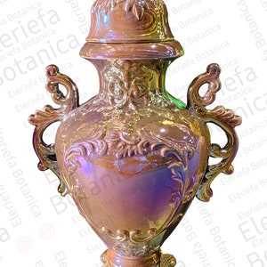 May include: A gold ceramic vase with ornate details and a lid. The vase has a pearlescent finish and a heart-shaped body.