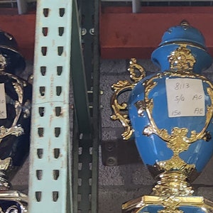 Pode incluir: Cinco bules de ch&aacute; de ouro e cer&acirc;mica adornados com al&ccedil;as decorativas. Os bules s&atilde;o de v&aacute;rias cores, incluindo amarelo, azul e rosa. Cada bule tem um r&oacute;tulo com o texto "2014 5th Annual"