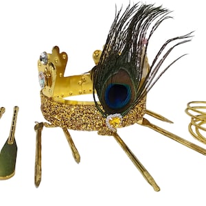 May include: A gold-colored crown with a peacock feather, rhinestones, and a gold glitter band. Includes gold-colored accessories: a knife, a spatula, and a set of bracelets.