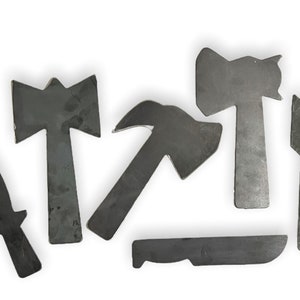 May include: Six metal tools shaped like a knife, hammer, axe, and arrow. The tools are all made of a dark gray metal and are arranged in a row on a white background.