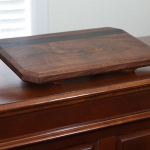 highly figured walnut cutting board with wooden feet image 1