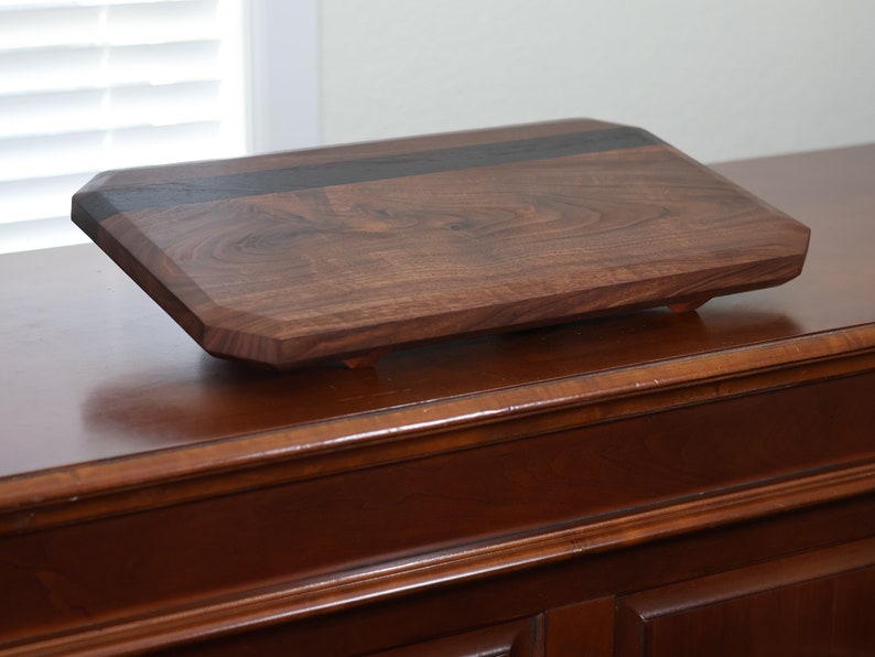 highly figured walnut cutting board with wooden feet image 1