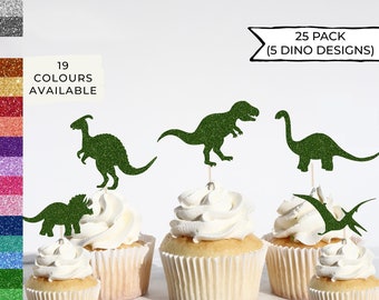 May include: A set of 25 green glitter dinosaur cupcake toppers. The toppers feature five different dinosaur designs: a T-Rex, a Brachiosaurus, a Triceratops, a Pterodactyl, and a Parasaurolophus. The text "25 PACK (5 DINO DESIGNS)" is printed on a white banner.