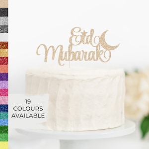 May include: Gold glitter cake topper with the words "Eid Mubarak" and a crescent moon and star.