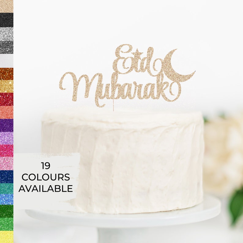 May include: Gold glitter cake topper with the words "Eid Mubarak" and a crescent moon and star.