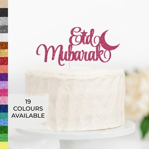 May include: Pink glitter cake topper with the words "Eid Mubarak" and a crescent moon and star.