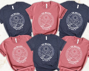 May include: A collection of short-sleeved t-shirts in shades of navy blue and dusty rose. Each shirt features a white circular graphic with a mountain and sun design, and the text "THE MILLERS FAMILY VACATION 2025 LAKE TAHOE, CA."