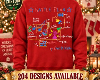 Op de afbeelding: Een rood sweatshirt met ronde hals en een grafische print van een plattegrond met het opschrift BATTLE PLAN door Kevin McCallister. Het ontwerp bevat handgetekende illustraties en tekst die vallen beschrijven zoals ijs, teer, vuur, lijm, veren en een ventilator.