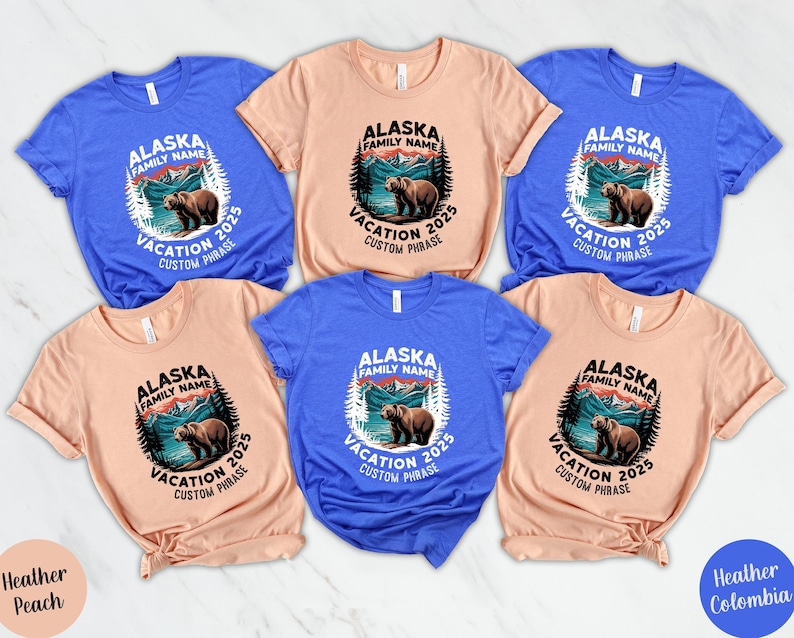 Peut inclure: Plusieurs t-shirts de couleurs vari&eacute;es, notamment bleu et p&ecirc;che. Chaque t-shirt arbore un motif circulaire avec l'inscription "Alaska Vacation 2025" et une illustration d'ours. Id&eacute;al pour les vacances en famille.