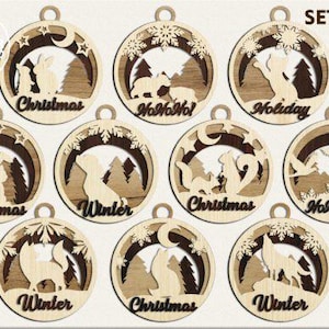 Op de afbeelding: Set van 10 lasergesneden houten kerstversieringen met verschillende winterse taferelen met dieren, waaronder een konijn, een eekhoorn, een beer, een wolf en een vos. De versieringen zijn versierd met sneeuwvlokken, sterren en de woorden "Kerstmis", "Winter" en "Ho Ho Ho!"