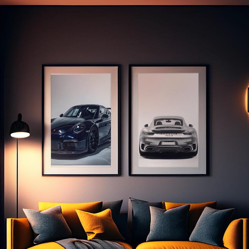 May include: Two framed prints of black and silver Porsche cars. The black car is facing the left and the silver car is facing the right. The prints are hanging on a dark gray wall.