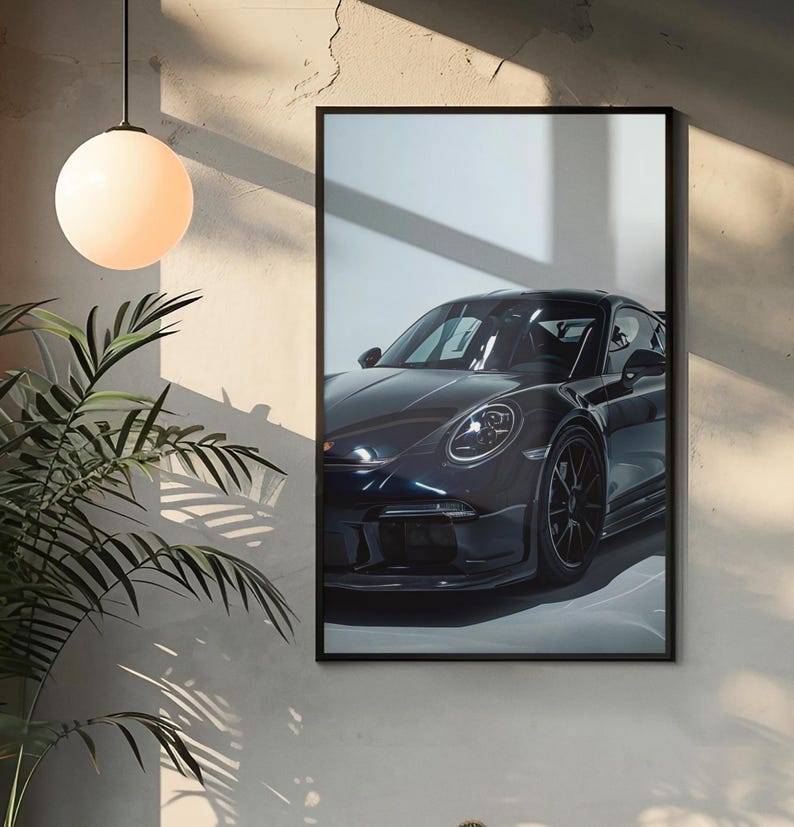 May include: A black Porsche sports car with a black interior, parked in a garage with a white wall and a window behind it. The car is facing the camera and the front headlights are visible.