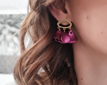 Boucles d'oreilles dorées et pétales de fleurs fuchsia rose