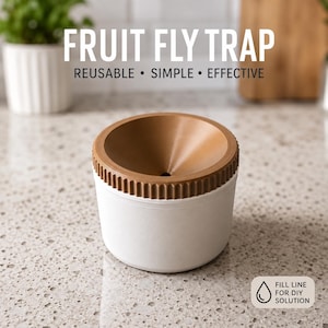 Puede incluir: Una trampa cilíndrica para moscas de la fruta con base blanca y parte superior marrón en forma de embudo. El texto FRUIT FLY TRAP REUSABLE • SIMPLE • EFFECTIVE es visible arriba, y una etiqueta indica FILL LINE FOR DIY SOLUTION con un icono.