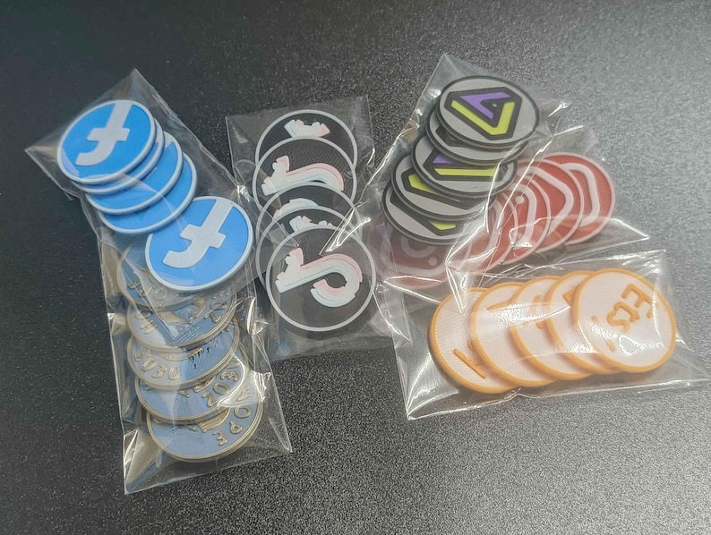 Pu&ograve; includere: Vari adesivi rotondi in sacchetti di plastica trasparente. I disegni includono un logo 'f' blu e bianco, un logo 'S' in bianco e nero, un design geometrico multicolore, cerchi rossi e cerchi arancioni con testo.