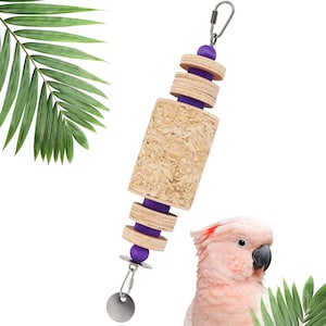 May include: A bird toy with a wooden and cork design, featuring a cylindrical cork centre and wooden discs separated by purple accents. It includes a metal clip and a small, round metal piece at the bottom. The toy is designed for birds.