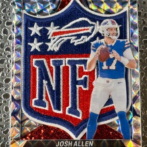 May include: A collectible trading card featuring Josh Allen of the Buffalo Bills. The card has a blue, red, and white NFL logo and a picture of Allen in his uniform. The card is encased in a shimmering, prismatic border.