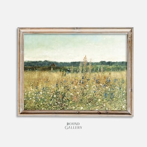 Op de afbeelding: Een ingelijst schilderij dat een veld met wilde bloemen in tinten blauw, wit en geel toont. Het veld bevindt zich op de voorgrond, met een rij bomen op de achtergrond. De lucht is lichtblauw met wat wolken.