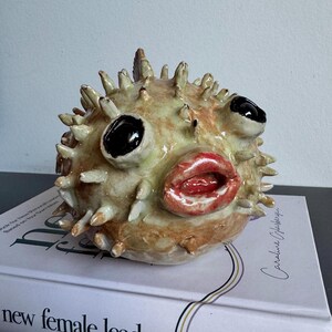 Handgemaakte keramische kogelvissculptuur, originele decoratie voor op een plank in kuststijl.