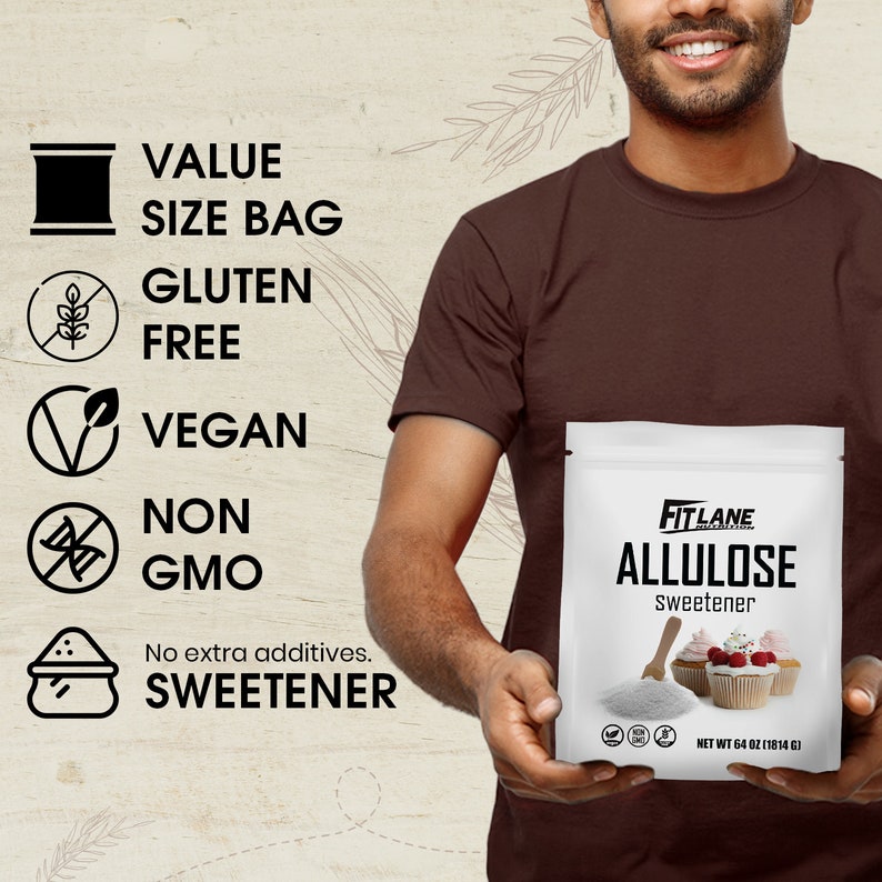 May include: A white bag of FitLane Allulose sweetener with a net weight of 64 ounces (1814 grams). The bag is held by a person. The bag has a label with the text "FitLane Allulose Sweetener" and a picture of two cupcakes with pink frosting and raspberries. The bag has a label with the text "HET WT 64 OZ (1814 G)". The bag has a label with a gluten-free symbol, a vegan symbol, and a non-GMO symbol.