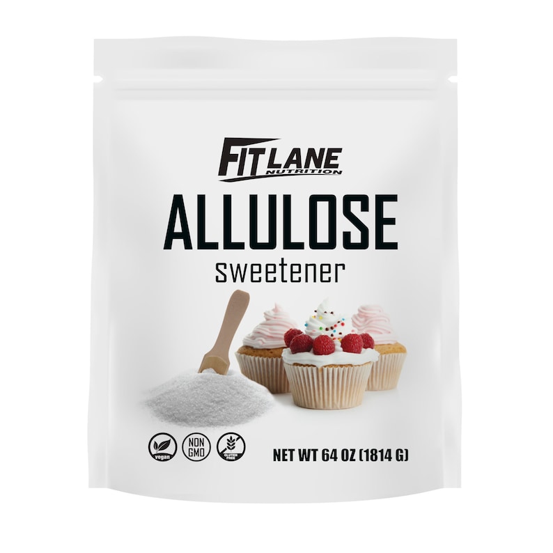 May include: A white bag of Fit Lane Nutrition Allulose sweetener, a sugar substitute. The bag is labeled with the product name, "Allulose Sweetener", and the net weight, "64 oz (1814 g)". The bag also features a vegan logo, a non-GMO logo, and a gluten-free logo. The bag is shown with a wooden spoon scooping out the white powder and three cupcakes with pink and white frosting.