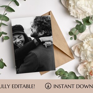 May include: A black and white photo of a couple hugging. The woman is wearing a hat and laughing. The man has a beard and is looking at the woman.
