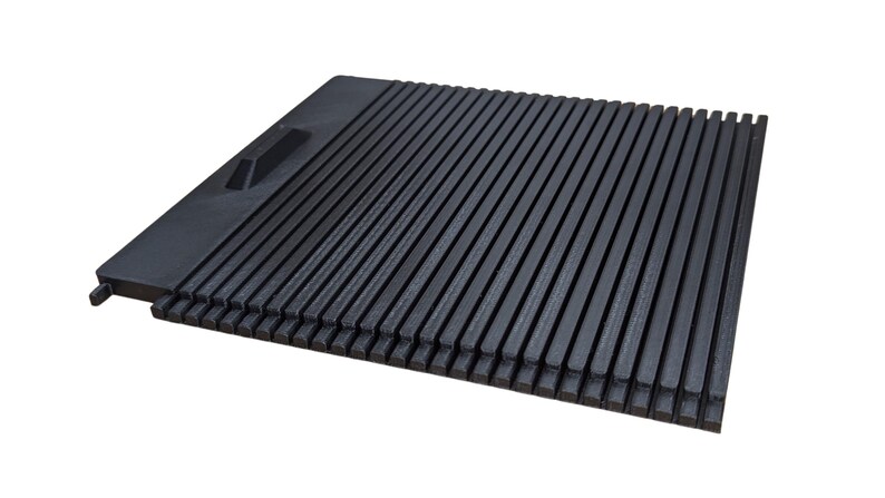 May include: Black plastic grill grate with a handle. The grate is made of thin, parallel slats.