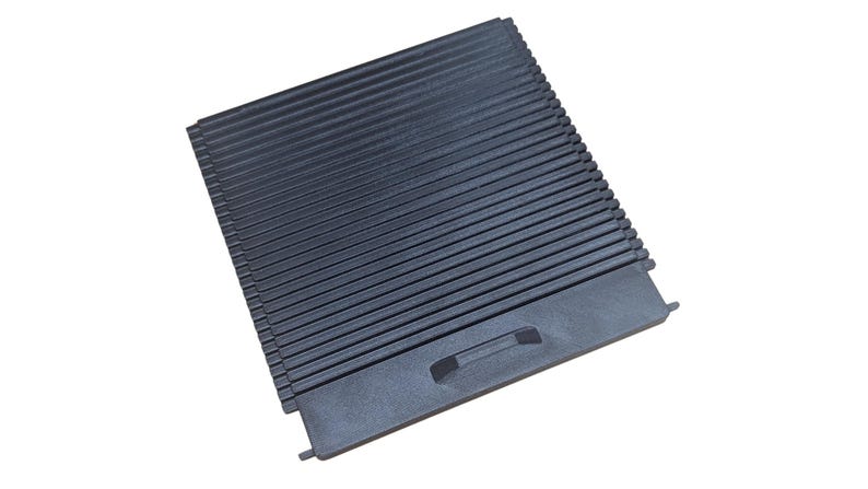 May include: Black plastic air vent grille with a rectangular shape and a handle on the bottom right side.