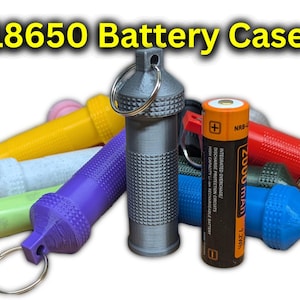 Könnte beinhalten: Ein graues 18650-Batteriegehäuse mit einer strukturierten Oberfläche und einem Schlüsselring. Das Gehäuse ist von anderen Batteriegehäusen in verschiedenen Farben umgeben, darunter Gelb, Blau, Rot und Grün. Der Text "18650 Battery Case" ist oben im Bild sichtbar.