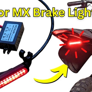 Może przedstawiać: Zestaw czerwonych świateł hamulcowych do motocykla terenowego Razor MX. Zestaw zawiera czerwone światło hamulcowe LED, czarną wiązkę przewodów i czarną skrzynkę konwertera. Światło hamulcowe jest zamontowane na tylnym błotniku motocykla.