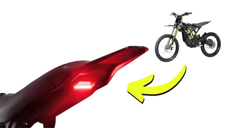 May include: A black electric motorcycle with yellow accents is shown next to a red tail light with a white light. A yellow arrow points from the tail light to the motorcycle. The motorcycle has black tires and a black seat.