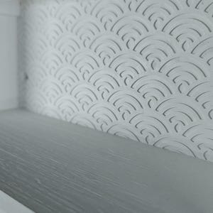 Peut inclure: Une &eacute;tag&egrave;re blanche dot&eacute;e d'un panneau arri&egrave;re avec un motif r&eacute;p&eacute;titif de demi-cercles en relief. La surface de l'&eacute;tag&egrave;re pr&eacute;sente une finition gris clair lisse. La structure comprend un cadre blanc avec des d&eacute;coupes circulaires.