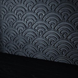 Peut inclure: Un panneau gris anthracite fonc&eacute; pr&eacute;sentant un motif en relief compos&eacute; de demi-cercles superpos&eacute;s. La texture de surface se compose de fines lignes parall&egrave;les &agrave; l'int&eacute;rieur de chaque arc, sur une base horizontale noire unie.