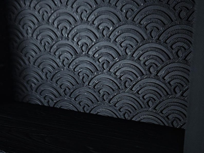 Peut inclure: Un panneau gris anthracite fonc&eacute; pr&eacute;sentant un motif en relief compos&eacute; de demi-cercles superpos&eacute;s. La texture de surface se compose de fines lignes parall&egrave;les &agrave; l'int&eacute;rieur de chaque arc, sur une base horizontale noire unie.