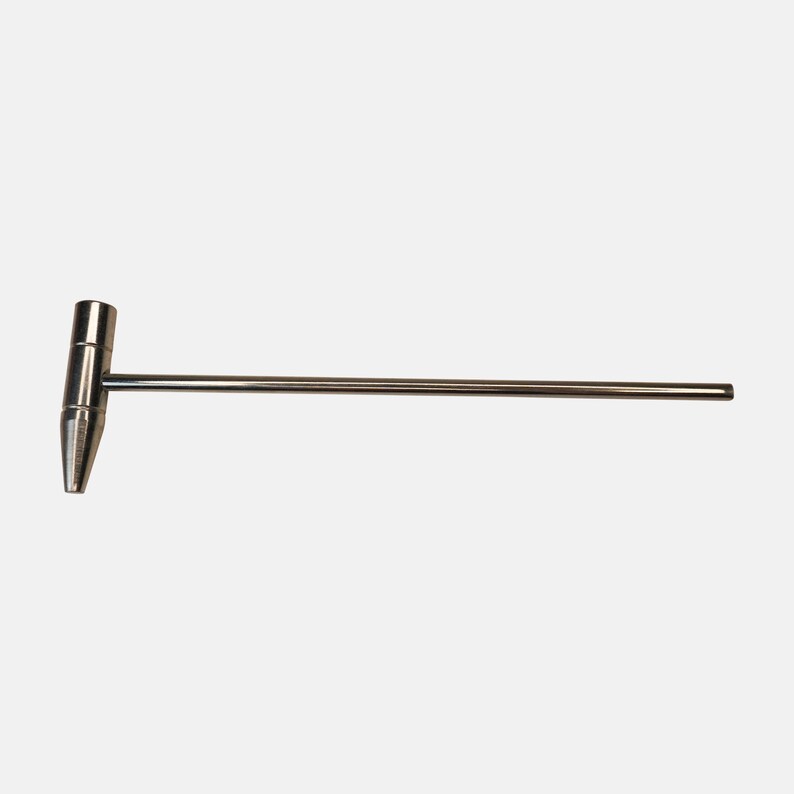 Puede incluir: Un martillo de metal plateado con un mango largo. El martillo tiene una cabeza puntiaguda.