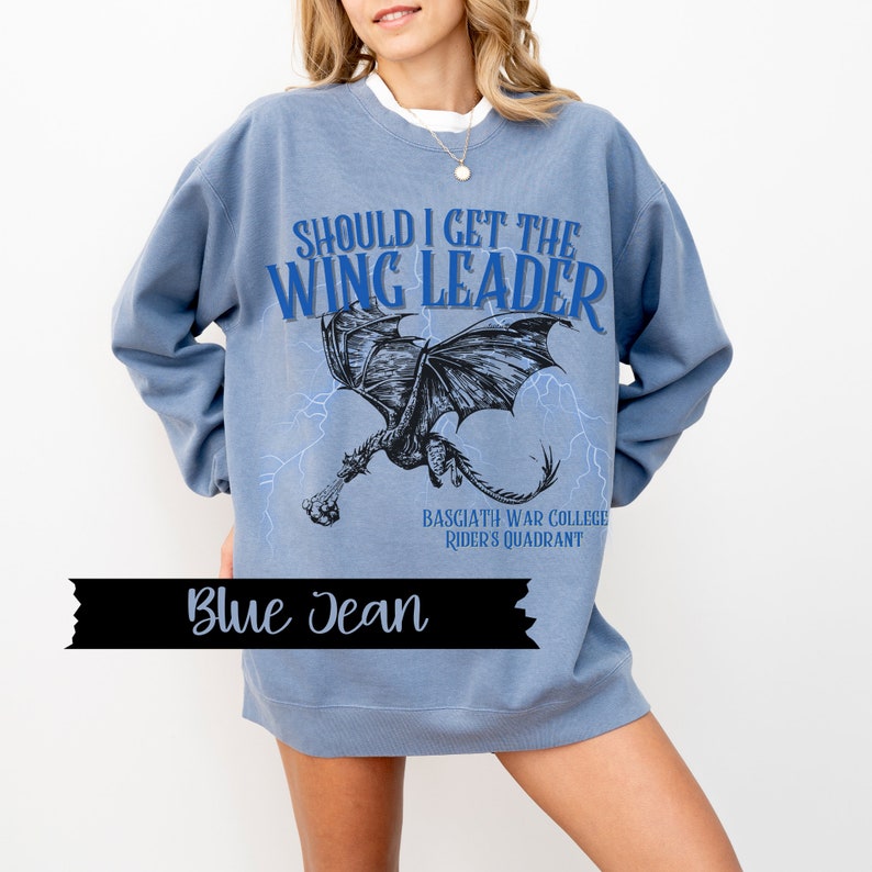May include: A blue jean sweatshirt with a graphic of a dragon and the text "Should I get the Wing Leader" and "Basgiath War College Rider's Quadrant".