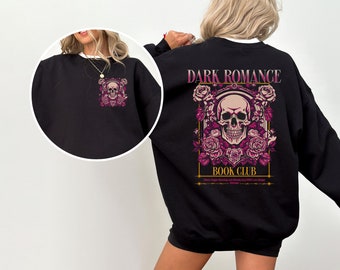 Peut inclure: Sweat-shirt noir avec col blanc. Il présente un motif de crâne et de roses à l'avant et, au dos, l'inscription "DARK ROMANCE BOOK CLUB" avec un motif de crâne et de roses en rose et or. Thème gothique.
