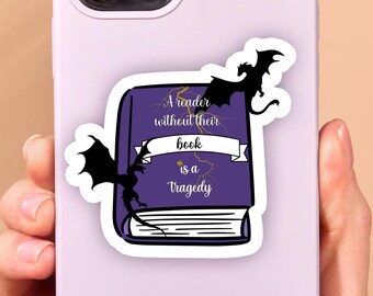 May include: A purple phone case with a sticker of a book with the text "A reader without their book is a tragedy" and two black dragons flying above the book.