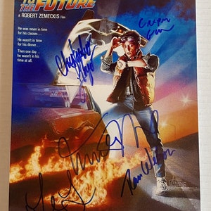 May include: A movie poster for the film "Back to the Future" featuring Michael J. Fox as Marty McFly. The poster is signed by the cast and crew, including Christopher Lloyd, Lea Thompson, and Robert Zemeckis.